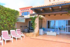 eine Terrasse mit roten und weißen Stühlen und einem Sofa in der Unterkunft Exclusive Villa Golf Private Pool in Adeje