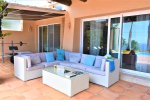 eine Terrasse mit einem Sofa und einem Couchtisch in der Unterkunft Exclusive Villa Golf Private Pool in Adeje + 37 Fotos