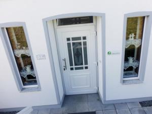 een witte deur in een kamer met twee spiegels bij Fewo Lüheblick im Haus Lühegarten in Grünendeich