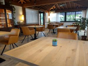 ein Restaurant mit einem großen Holztisch und Stühlen in der Unterkunft Agriturismo Il Cavallino Saturnia in Semproniano