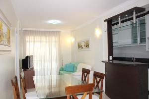 a kitchen and a dining room with a glass table at Ingleses Ocean View in Florianópolis