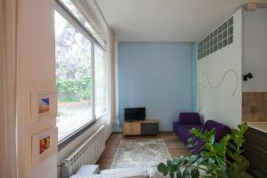 sala de estar con sofá y ventana grande en Loft Sottolalbero en Milán