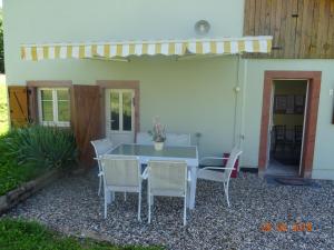 a table and chairs in front of a house at La maison dans les prés in Labaroche