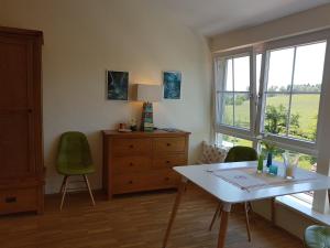 a room with a table and chairs and a window at Landgut Apfelrose in Friedrichshafen