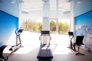 a gym with two tread machines and a large window at Schwitzer's Hotel am Park in Waldbronn