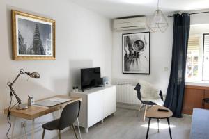 sala de estar con escritorio y TV en Apartamento Casa de Campo, en Madrid