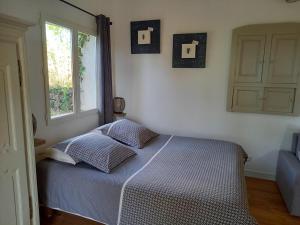 a bed in a bedroom with two crosses on the wall at GITE AVEC SPA JACUZZI au cœur de Provence Côte d'Azur in Saint Antonin du Var