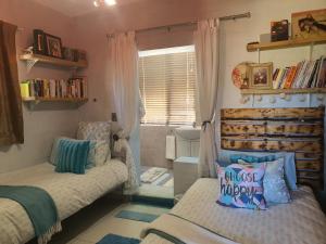a small bedroom with two beds and a window at Clanwilliam Hills House in Clanwilliam