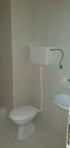 a white bathroom with a toilet and a sink at Becici rooms in Becici