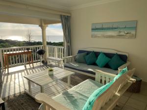 een woonkamer met een bank en een tafel op een balkon bij Unit 4 Umzimkulu - Mangroves beach estate in Melville