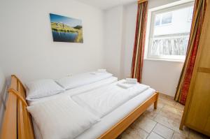 una camera da letto con un letto con lenzuola bianche e una finestra di Penthouse in the heart of Zell am See a Zell am See Altre 37 foto