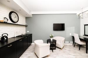 a kitchen with a table and a clock on the wall at Native Apartments Sukiennicza 8 in Krakow