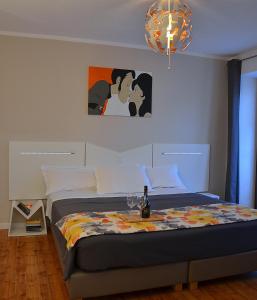 Un dormitorio con una cama con una botella de vino. en BB BORGO BIELLA, en Candelo