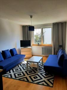 a living room with blue couches and a coffee table at Old Town Apartment in Malbork