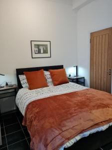 ein Schlafzimmer mit einem großen Bett mit orangefarbenen Kissen in der Unterkunft No.8 in Stornoway