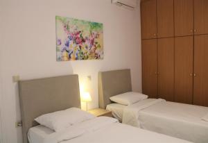 um quarto com duas camas e um quadro na parede em Kalamaki Plaza Apartments em Kalamaki