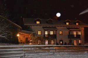 a large house at night with the moon in the sky at Landhof Fischer in Geiersthal +4 photos