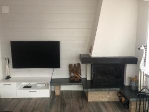 sala de estar con chimenea y TV de pantalla plana en Les Dents-du-Midi, en Monthey