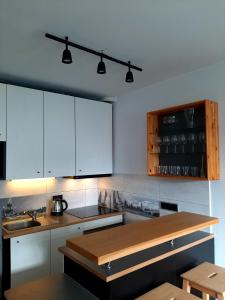 a kitchen with white cabinets and a wooden counter top at Old Town Apartment in Malbork