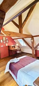 a bedroom with a large bed and a desk at La Maison de Caroline in Westhoffen