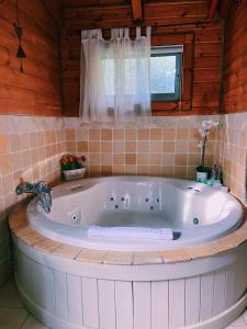 uma grande banheira branca num quarto com uma janela em Julie's Cabins em Neot Golan