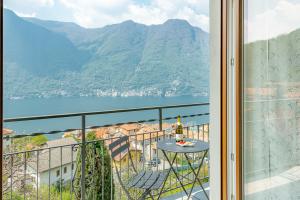 a balcony with a table and a view of a mountain at Dea House in Nesso +35 photos