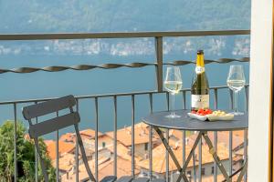 a table with two glasses and a bottle of wine at Dea House in Nesso
