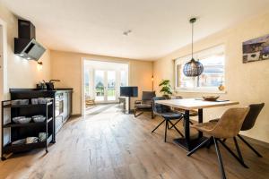 a living room with a table and chairs and a kitchen at Bergheimat Tirol in Lermoos