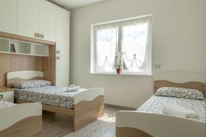 una camera con due letti e una finestra di Dea House a Nesso