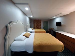 Ένα ή περισσότερα κρεβάτια σε δωμάτιο στο Scottish Inns & Suites