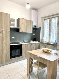 a kitchen with a table and a sink and a stove at LE PALME Loft Apartment in Fossano