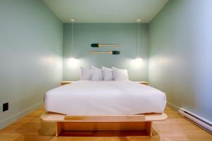 a large white bed in a room with green walls at Les Lofts Dorchester - Par Les Lofts Vieux-Québec in Quebec City