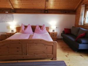 a bedroom with a large bed and a couch at Hochfelner-Prutti - Stockerhof in Sankt Marein bei Knittelfeld