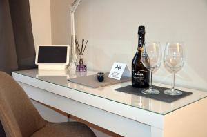 a desk with a bottle of wine and two wine glasses at BB Borgo Biella in Candelo