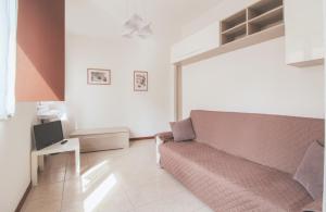 a living room with a couch and a tv at Mimosa 24 in Acquaseria