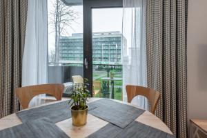 een eetkamer met een tafel en een groot raam bij Eva R Apartments in Druskininkai