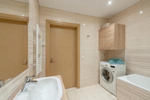 een badkamer met wastafel en wasmachine bij Eva R Apartments in Druskininkai +20 foto's