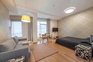 een slaapkamer met een bed, een bank en een tafel bij Eva R Apartments in Druskininkai