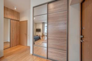 een glazen schuifdeur in een kamer met een slaapkamer bij Eva R Apartments in Druskininkai