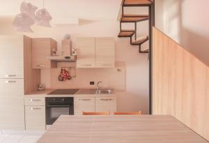 a kitchen with a wooden table and a staircase at Mimosa 24 in Acquaseria