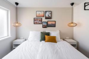 1 dormitorio con 1 cama blanca grande con 3 luces en Charley's Home 2 personen, en Westkapelle