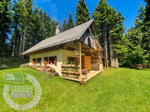 een klein huis met een groen landgoed bord ervoor bij MOUNTAIN ECO CHALET KONJSKA DOLINA on 1400 m asl -near Pokljuka in Srednja Vas v Bohinju