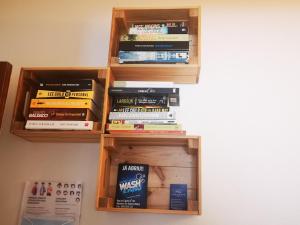 a book shelf filled with books on a wall at Family Surf Home - Hostel in Mafra