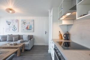 een keuken en een woonkamer met een bank en een tafel bij Seaside in Westerland
