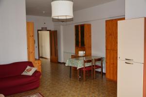 Una sala de estar con una mesa y un sofá rojo. en Appartamento AL 30, en Marzocca di Senigallia