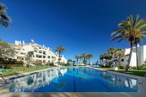 a large swimming pool in front of a large building at Coral Beach Aparthotel in Marbella