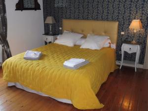 a bedroom with a yellow bed with two towels on it at LES TERRES BASSES in Fabrezan