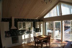 a kitchen with a table and chairs and a large window at Sjöställe Gudö in Vendelsö