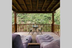 a screened porch with couches and a table on a deck at Casa do Avô Alváro - Refugio do Rei in Casal do Rei