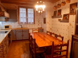 una cocina con mesa de madera y sillas. en Eth Caneba, en Mont